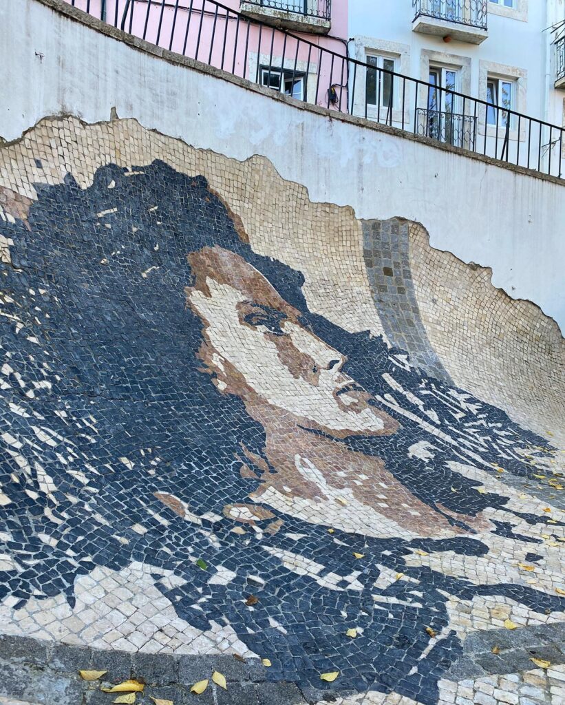Alfama in Lisbon: A Tourist Guide 16 Vibrant mosaic mural of a woman's face in Alfama, Lisbon, showcasing traditional tile art and local culture.