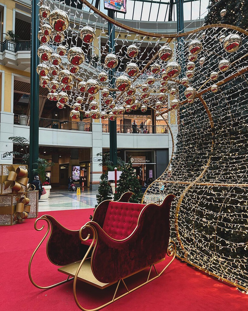 11 Christmas Markets in Lisbon 2026 1 Festive Christmas decorations in a Lisbon shopping mall, featuring hanging ornaments, a sleigh, and Christmas trees, creating a joyful holiday atmosphere.