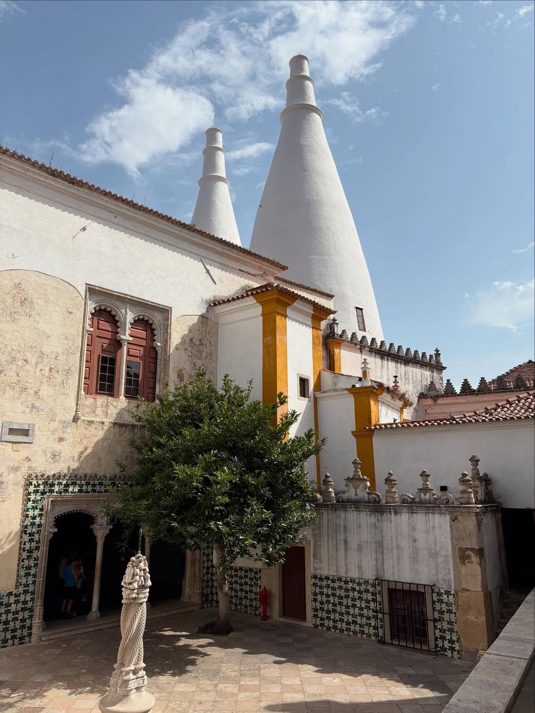 21 Amazing Castles in Lisbon and Its Surroundings 11 Old Portuguese church with distinctive white bell towers and intricate architectural details, surrounded by traditional tiled walls and lush greenery in Lisbon, Portugal.