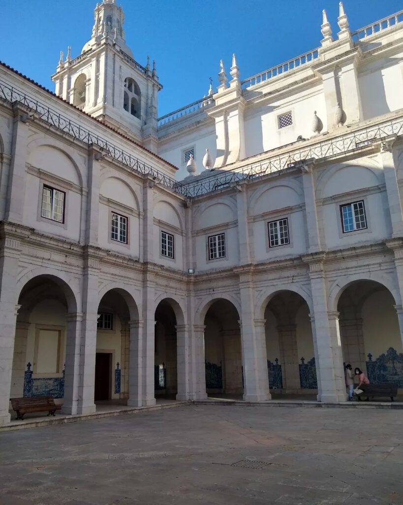 Alfama in Lisbon: A Tourist Guide 15 Alfama in Lisbon features historic white buildings with elegant arches and a bright blue sky, showcasing the charm of Lisbon's oldest district.