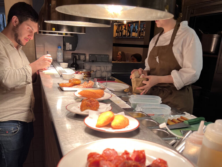 Succulent chorizo sausages served at a bustling Lisbon restaurant, showcasing authentic Portuguese cuisine in a cozy, vibrant atmosphere perfect for food lovers exploring Lisbon’s local flavors.