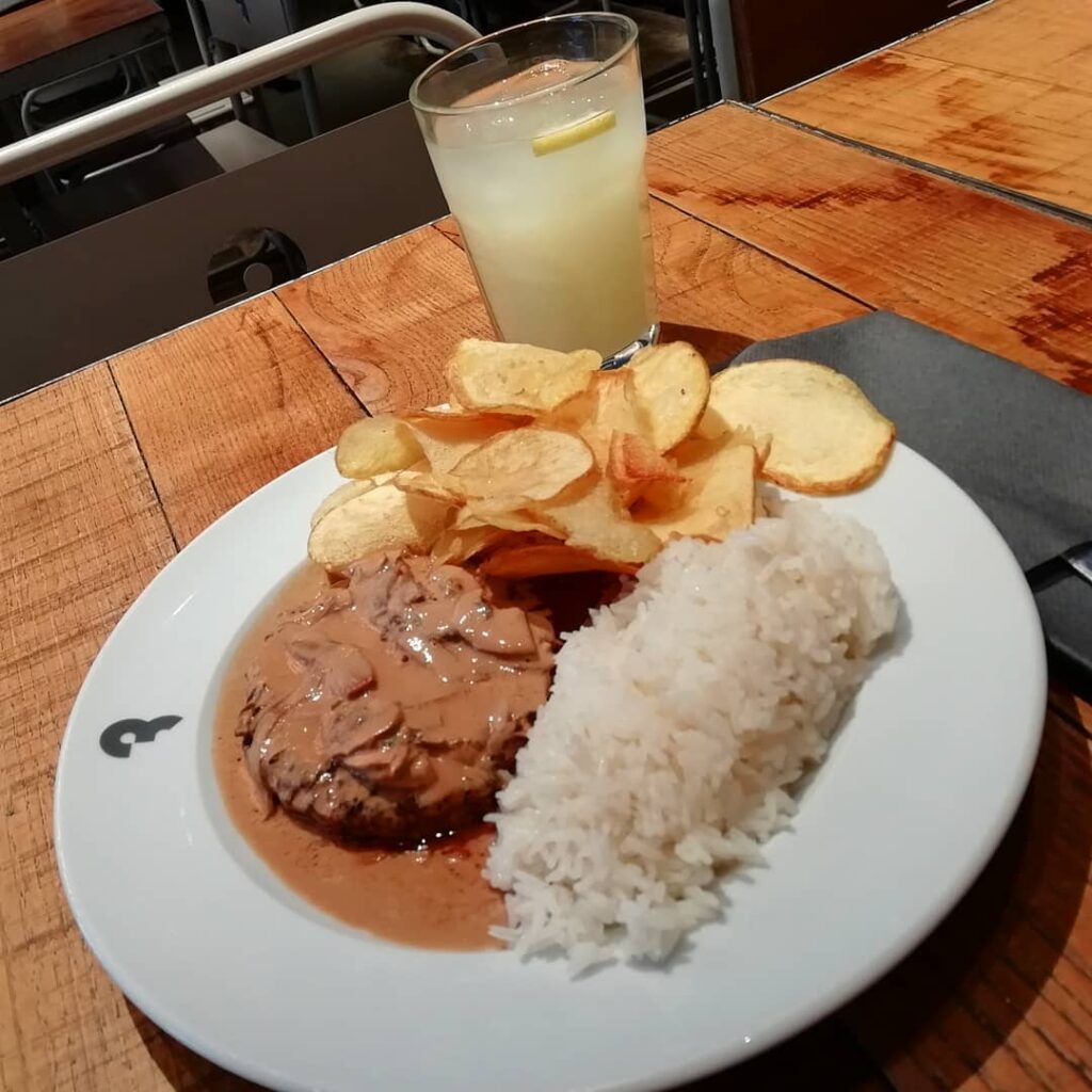 6 Best Portuguese Restaurants in Lisbon (Local & Authentic) 7 Creamy mushroom sauce over tender beef steak with white rice, crispy potato chips, and a refreshing lemonade with lemon slices on a wooden table in Lisbon. Perfect for a relaxing Lisbon dining experience.