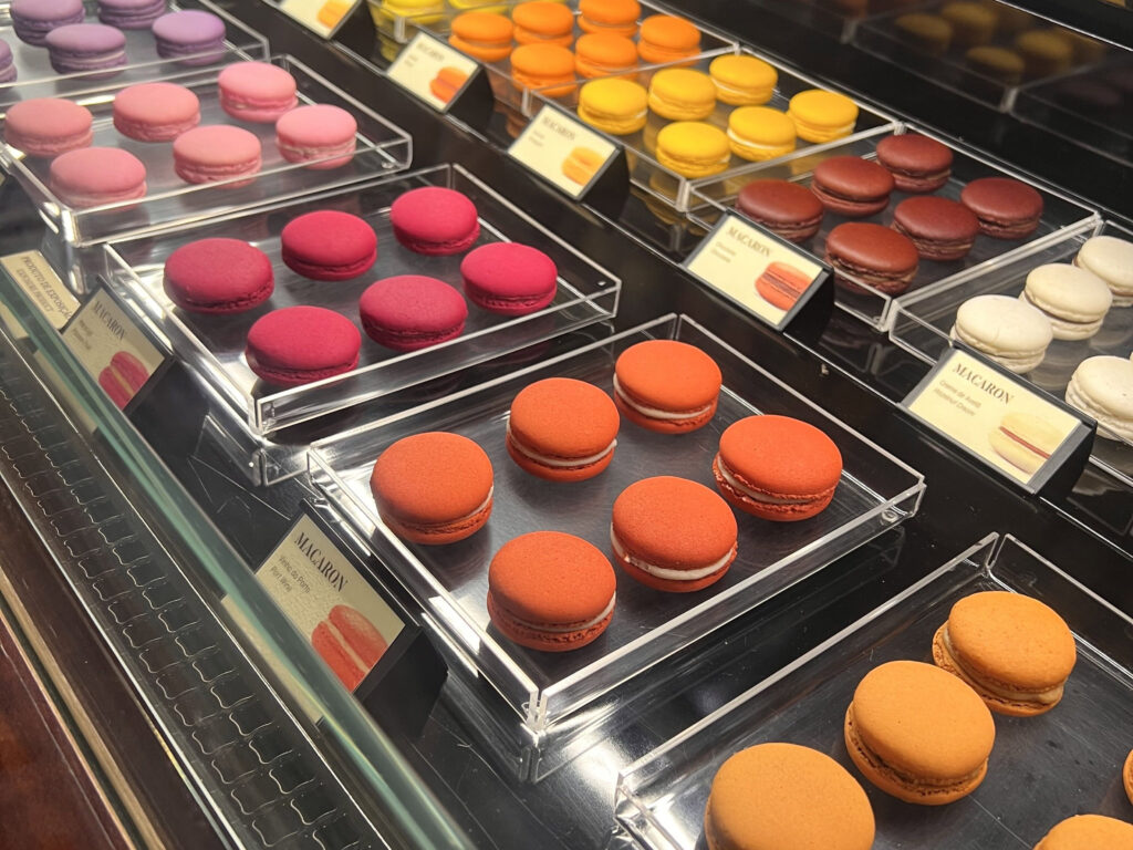 Lisbon Food Guide: What to Eat + Where to Eat (Local Tips + Map) 7 Brightly colored macarons displayed in a pastry case, showcasing popular Portuguese sweet treats in Lisbon. Perfect for dessert lovers exploring Lisbon's vibrant culinary scene.