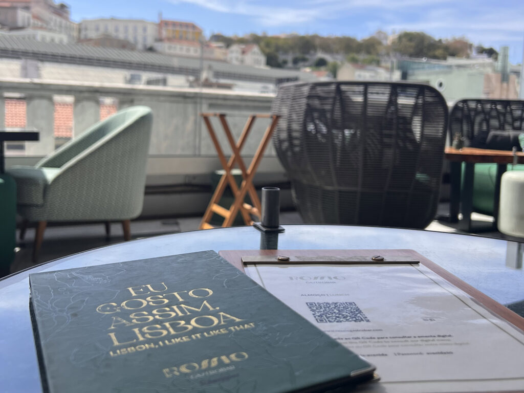 Lisbon Food Guide: What to Eat + Where to Eat (Local Tips + Map) 9 Enjoying a sunny day at a Lisbon rooftop terrace with stunning city views, stylish seating, and a delicious menu, experiencing the vibrant LisboaVibes with authentic Portuguese cuisine.